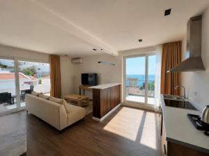 a living room with a couch and a kitchen with a view at Donna in Ulcinj