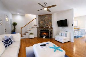 a living room with a white couch and a fireplace at Sunny Side Up in Oak Bluffs