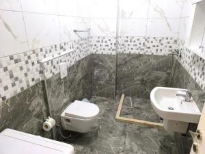 a bathroom with a toilet and a sink at Astir Apartments in Tirana +9 photos