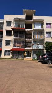 a large apartment building with cars parked in front of it at Palmera africana 1 in Los Paredones