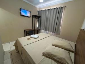 a small bedroom with a bed and a television at Pé da Serra Hotel in Resende +44 photos