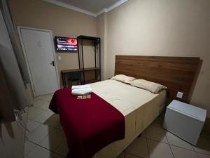 a bedroom with a bed with a red blanket at Pé da Serra Hotel in Resende