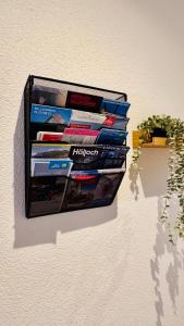 a rack of books on a wall with a plant at Mountainview Apartment - Central - Family - Hiking - Lake and Mountains in Schwyz