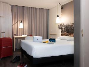 a hotel room with a bed with a laptop on it at ibis Chia in Chía