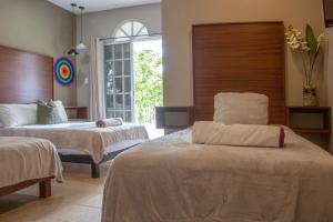 a hotel room with two beds and a window at Villas Aura in Mérida +8 photos