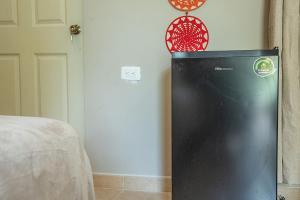 a black refrigerator in a room with a clock on the wall at Villas Aura in Mérida