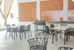 a dining room with tables and chairs and a piano at Villas Aura in Mérida
