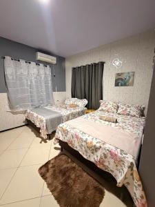 a bedroom with two beds and a window at Casa Dunas Temporada in Barreirinhas