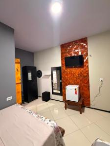 a bedroom with a bed and a tv on a wall at Casa Dunas Temporada in Barreirinhas
