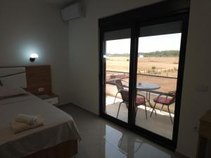 a bedroom with a bed and a balcony with a table and chairs at Caci Apartments in Gornji Štoj