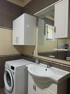 a bathroom with a sink and a washing machine at Milos Apartments in Himare +29 photos