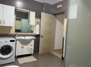 a bathroom with a washing machine and a sink at Milos Apartments in Himare