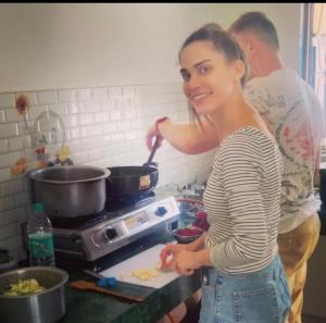 a woman standing in a kitchen preparing food at Hostel Arabbian nights in Khajurāho