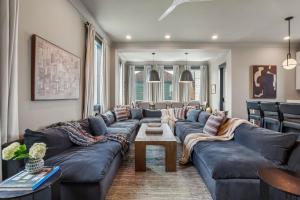 a living room with a large couch and a table at 7BR City Condo & Pool Access Near CBD in New Orleans