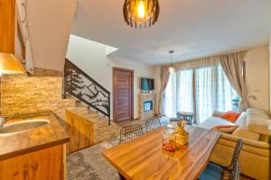 a kitchen and living room with a table and a couch at Brvnara Mont in Zlatibor