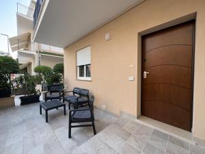 a garage with four chairs and a wooden door at Colombo Boutique Rooms in Tortoreto Lido