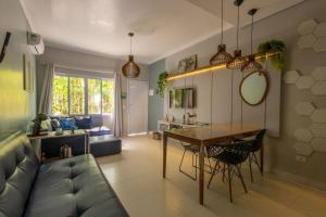 a living room with a couch and a table at Flat completo e charmoso no centro de Juquehy in São Sebastião