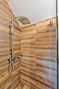 a bathroom with a shower with wood paneling at Brvnara Mont in Zlatibor +11 photos