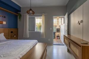 a bedroom with a bed and a large window at Flat completo e charmoso no centro de Juquehy in São Sebastião