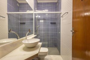 a bathroom with a toilet and a sink and a shower at Flat completo e charmoso no centro de Juquehy in São Sebastião +19 photos