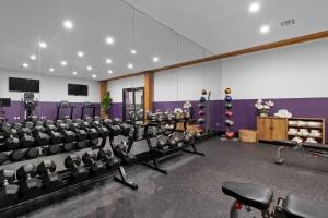 a room with chairs and a gym with purple walls at King Bed Prime Location Downtown Hotel Suite in New Orleans
