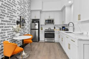 a kitchen with white cabinets and orange chairs at King Bed Prime Location Downtown Hotel Suite in New Orleans