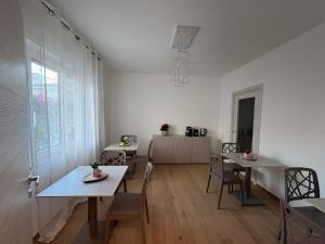 a living room with two tables and chairs and a kitchen at Colombo Boutique Rooms in Tortoreto Lido