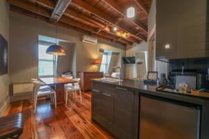 a kitchen with a table and a dining room at Le Pleasant Hôtel in Sutton