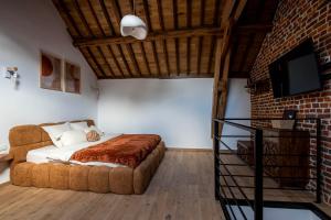 a bedroom with a bed and a brick wall at Domaine de Donstiennes in Thuin