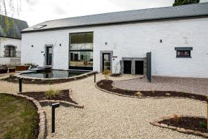 a white building with a courtyard with a fountain at Domaine de Donstiennes in Thuin