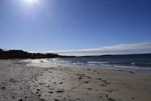 a beach with footprints in the sand and the ocean at Spacious home in Machrihanish in Machrihanish +11 photos