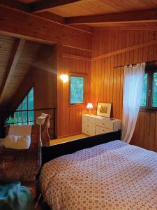 a bedroom with a bed in a room with wooden walls at Landscape Casa de Madera in Tarragona