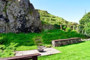 a garden with a stone bench and a stone wall at Spacious home in Machrihanish in Machrihanish