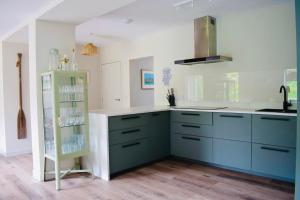 a kitchen with blue and white cabinets and a shelf at Spacious home in Machrihanish in Machrihanish