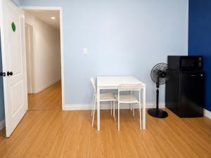 a white table and chairs in a room with a refrigerator at one bedroom in Brampton in Brampton
