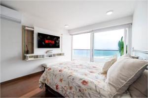 a bedroom with a bed and a large window at OceanFront Larcomar Apartments in Lima