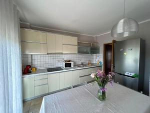a kitchen with a table and a vase of flowers at Apartment golem in Durrës