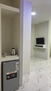 a kitchen with a refrigerator and a tiled floor at فندق الحزم الرستاق Alhazm Hotel Alrustaq in Ḩazm