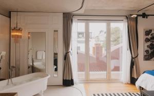 a bathroom with a tub and a large window at Maximo Mexico Roma in Mexico City +73 photos