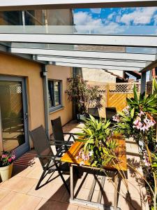 a patio with a table and chairs and plants at Ferienwohnung am Kastanienbusch in Birkweiler
