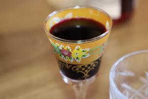 a glass of red wine sitting on a table at Hotel - Old Ushguli in Ushguli +90 photos