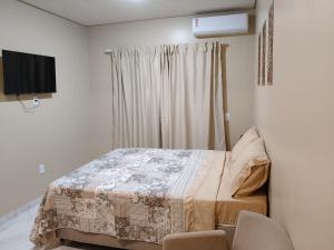 a bedroom with a bed and a television in it at Hospedaria Lençóis in Barreirinhas