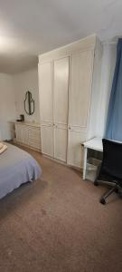 a bedroom with a bed and a desk and cabinets at Standard Double Room with Shared Bathroom in London