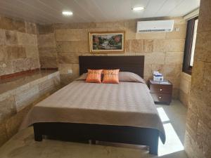 a bedroom with a bed with two orange pillows at Moufid villa in Al Mīdān