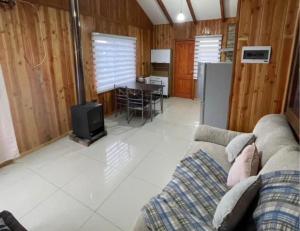 a living room with a couch and a stove at Hospedaje Canarias in Pucón