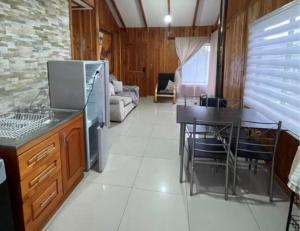 a kitchen and dining room with a table and refrigerator at Hospedaje Canarias in Pucón
