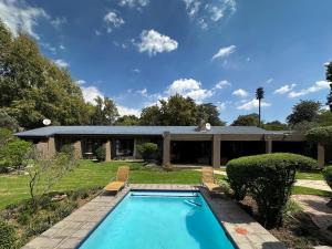 a swimming pool in the yard of a house at Sand River Guest House in Johannesburg