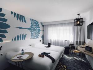a hotel room with a bed and a desk with a laptop at ibis Styles Nancy Laxou in Nancy +65 photos