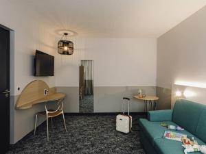 a living room with a couch and a table at ibis Styles Nancy Laxou in Nancy
