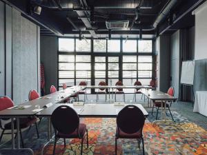 a conference room with tables and chairs and a large window at ibis Styles Nancy Laxou in Nancy